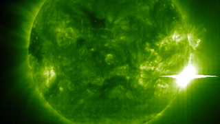 A solar flare is an intense burst of radiation coming from the release of magnetic energy associated with sunspots. Flares are our solar system's largest explosive events. They are seen as bright areas on the sun and they can last from minutes to hours. We typically see a solar flare by the photons (or light) it releases, at most every wavelength of the spectrum. The primary ways we monitor flares are in x-rays and optical light. Flares are also sites where particles (electrons, protons, and heavier particles) are accelerated.