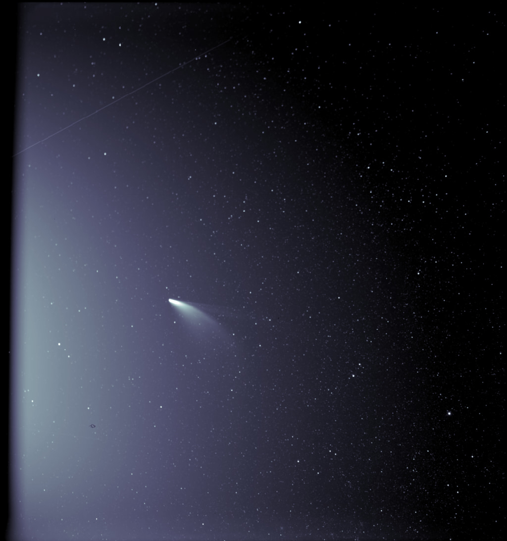An unprocessed image from the WISPR instrument on board NASA’s Parker Solar Probe shows comet NEOWISE on July 5, 2020, shortly after its closest approach to the Sun. The Sun is out of frame to the left. The white streak near the upper left corner of the image is light reflected off a grain of dust that passed through the instrument’s field of view during the observation. The faint grid pattern near the center of the image is an artifact of the way the image is created. The small black structure near the lower left of the image is caused by a grain of dust resting on the imager’s lens. Credit: NASA/Johns Hopkins APL/Naval Research Lab/Parker Solar Probe/Brendan Gallagher