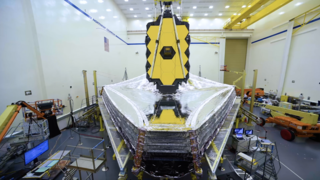 The James Webb Space Telescope (sometimes called JWST) is a large, infrared-optimized space telescope. The project is working to a 2021 launch date. Webb will find the first galaxies that formed in the early Universe, connecting the Big Bang to our own MIlky Way Glaxy. Webb will peer through dusty clouds to see stars forming planetary systems, connecting the Milky Way to our own Solar System. Webb's instruments are designed to work primarily in the infrared range of the electromagnetic spectrum, with some capability in the visible range.

Webb will have a large primary mirror, 6.5 meters (21.3 feet) in diameter and a sunshield the size of a tennis court. Both the mirror and sunshade won't fit onto the Ariane 5 rocket fully open, so both will fold up and open once Webb is in outer space. Webb will operate in an orbit about 1.5 million km (1 million miles) from the Earth.

The James Webb Space Telescope was named after the NASA Administrator who crafted Apollo program, and who was a staunch supporter of space science.