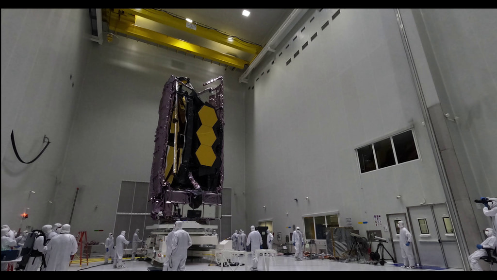 Time lapse b-roll of the Webb Telescope being removed from the protective enclosure the telescope was encased in while inside its shipping container.  The Telescope is tilted upright in the launch site cleanroom.  