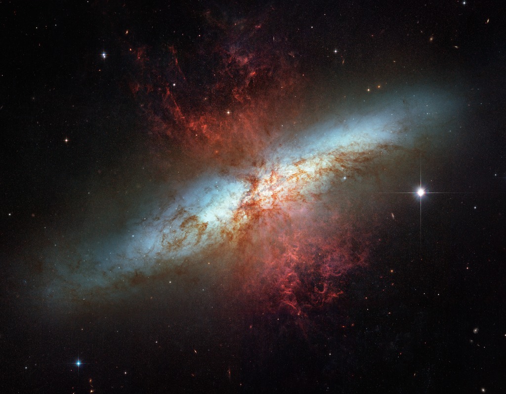 Plumes of glowing hydrogen blast from the central nucleus of the starburst galaxy Messier 82.